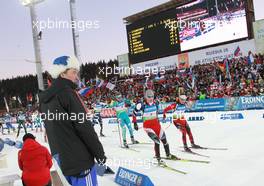 11.03.2011, Khanty-Mansiysk, Russia (RUS): Chief of Competition watches Simon Eder (AUT), Fischer, Rottefella, Swix and Ole Einar Bjoerndalen (NOR), Madshus, Rottefella, Odlo - IBU world championships biathlon, relay men, Khanty-Mansiysk (RUS). www.xpb.cc. © Manzoni/xpb.cc. Every downloaded picture is fee-liable.