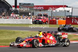Fernando Alonso (ESP) Ferrari F14-T and Sebastian Vettel (GER) Red Bull Racing RB10 battle for position. 06.07.2014. Formula 1 World Championship, Rd 9, British Grand Prix, Silverstone, England, Race Day.