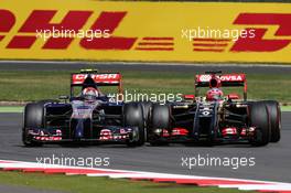 Daniil Kvyat (RUS) Scuderia Toro Rosso STR9 and Romain Grosjean (FRA) Lotus F1 E22 battle for position. 06.07.2014. Formula 1 World Championship, Rd 9, British Grand Prix, Silverstone, England, Race Day.