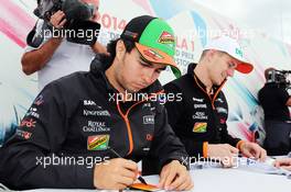 (L to R): Sergio Perez (MEX) Sahara Force India F1 and team mate Nico Hulkenberg (GER) Sahara Force India F1 sign autographs for the fans. 05.07.2014. Formula 1 World Championship, Rd 9, British Grand Prix, Silverstone, England, Qualifying Day.