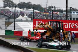 Nico Rosberg (GER) Mercedes AMG F1 W05 passes the stricken Ferrari F14-T of Fernando Alonso (ESP) Ferrari, which is removed by marshals using a digger. 05.10.2014. Formula 1 World Championship, Rd 15, Japanese Grand Prix, Suzuka, Japan, Race Day.