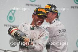 Race winner Lewis Hamilton (GBR) Mercedes AMG F1 celebrates on the podium with second placed team mate Nico Rosberg (GER) Mercedes AMG F1. 30.03.2014. Formula 1 World Championship, Rd 2, Malaysian Grand Prix, Sepang, Malaysia, Sunday.