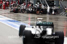 Nico Rosberg (GER) Mercedes AMG F1 W05 enters the pits as Lewis Hamilton (GBR) Mercedes AMG F1 W05 makes a pit stop. 29.03.2014. Formula 1 World Championship, Rd 2, Malaysian Grand Prix, Sepang, Malaysia, Saturday.