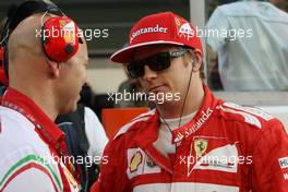 Kimi Raikkonen (FIN) Ferrari with Mark Arnall (GBR) Personal Trainer on the grid. 23.11.2014. Formula 1 World Championship, Rd 19, Abu Dhabi Grand Prix, Yas Marina Circuit, Abu Dhabi, Race Day.