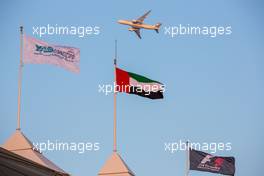 Yas Marina Circuit flags, UAE flag, F1 flag, and an Etifad airplane.  20.11.2014. Formula 1 World Championship, Rd 19, Abu Dhabi Grand Prix, Yas Marina Circuit, Abu Dhabi, Preparation Day.