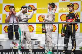 The podium (L to R): race winner Lewis Hamilton (GBR) Mercedes AMG F1 celebrates with the champagne with second placed team mate Nico Rosberg (GER) Mercedes AMG F1 and third placed Romain Grosjean (FRA) Lotus F1 Team. 23.08.2015. Formula 1 World Championship, Rd 13, Belgian Grand Prix, Spa Francorchamps, Belgium, Race Day.