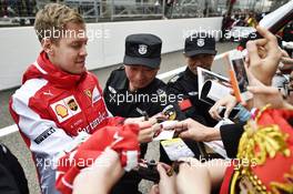 Sebastian Vettel (GER) Ferrari signs autographs for the fans. 09.04.2015. Formula 1 World Championship, Rd 3, Chinese Grand Prix, Shanghai, China, Preparation Day.