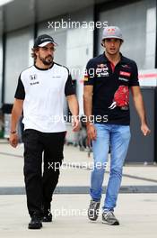 (L to R): Fernando Alonso (ESP) McLaren with Carlos Sainz Jr (ESP) Scuderia Toro Rosso. 03.07.2015. Formula 1 World Championship, Rd 9, British Grand Prix, Silverstone, England, Practice Day.