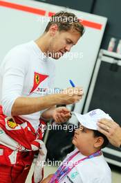Sebastian Vettel (GER) Ferrari with a young fan. 03.07.2015. Formula 1 World Championship, Rd 9, British Grand Prix, Silverstone, England, Practice Day.