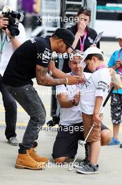 Lewis Hamilton (GBR) Mercedes AMG F1 with a young fan. 03.07.2015. Formula 1 World Championship, Rd 9, British Grand Prix, Silverstone, England, Practice Day.
