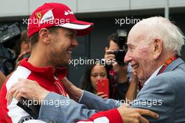 (L to R): Sebastian Vettel (GER) Ferrari with John Surtees (GBR). 05.07.2015. Formula 1 World Championship, Rd 9, British Grand Prix, Silverstone, England, Race Day.