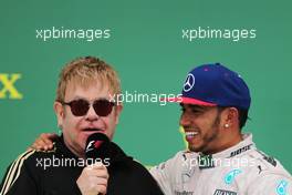 The podium (L to R): Sir Elton John (GBR) with race winner and World Champion Lewis Hamilton (GBR) Mercedes AMG F1 on the podium. 25.10.2015. Formula 1 World Championship, Rd 16, United States Grand Prix, Austin, Texas, USA, Race Day.