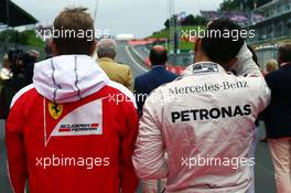 (L to R): Kimi Raikkonen (FIN) Ferrari and Lewis Hamilton (GBR) Mercedes AMG F1 as the grid observes the national anthem. 03.07.2016. Formula 1 World Championship, Rd 9, Austrian Grand Prix, Spielberg, Austria, Race Day.