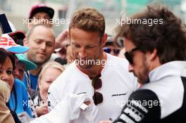 (L to R): Jenson Button (GBR) McLaren and team mate Fernando Alonso (ESP) McLaren sign autographs for the fans. 07.07.2016. Formula 1 World Championship, Rd 10, British Grand Prix, Silverstone, England, Preparation Day.