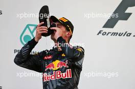 Max Verstappen (NLD) Red Bull Racing celebrates his second position on the podium  by drinking champagne from the race boot of race winner Daniel Ricciardo (AUS) Red Bull Racing. 02.10.2016. Formula 1 World Championship, Rd 16, Malaysian Grand Prix, Sepang, Malaysia, Sunday.
