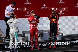 The podium (L to R): race winner Valtteri Bottas (FIN) Mercedes AMG F1 celebrates with the champagne with third placed Daniel Ricciardo (AUS) Red Bull Racing and second placed Sebastian Vettel (GER) Ferrari. 09.07.2017. Formula 1 World Championship, Rd 9, Austrian Grand Prix, Spielberg, Austria, Race Day.