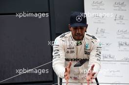 Race winner Lewis Hamilton (GBR) Mercedes AMG F1 catches his smartphone on the podium. 16.07.2017. Formula 1 World Championship, Rd 10, British Grand Prix, Silverstone, England, Race Day.