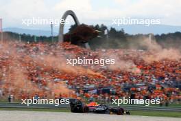 Max Verstappen (NLD) Red Bull Racing RB19 passes fans in the grandstand with flares being set off. 30.06.2023. Formula 1 World Championship, Rd 10, Austrian Grand Prix, Spielberg, Austria, Qualifying Day.