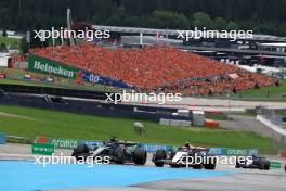 George Russell (GBR) Mercedes AMG F1 W14 and Yuki Tsunoda (JPN) AlphaTauri AT04 battle for position. 02.07.2023. Formula 1 World Championship, Rd 10, Austrian Grand Prix, Spielberg, Austria, Race Day.