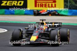 Max Verstappen (NLD) Red Bull Racing RB19 passes Sergio Perez (MEX) Red Bull Racing RB19, who crashed in the first practice session. 21.07.2023. Formula 1 World Championship, Rd 12, Hungarian Grand Prix, Budapest, Hungary, Practice Day.