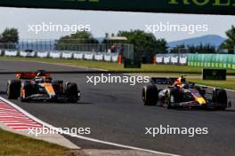 Oscar Piastri (AUS) McLaren MCL60 and Sergio Perez (MEX) Red Bull Racing RB19 battle for position. 23.07.2023. Formula 1 World Championship, Rd 12, Hungarian Grand Prix, Budapest, Hungary, Race Day.