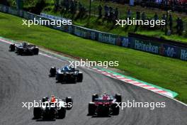 Sergio Perez (MEX) Red Bull Racing RB19 and Zhou Guanyu (CHN) Alfa Romeo F1 Team C43 battle for position. 24.09.2023. Formula 1 World Championship, Rd 17, Japanese Grand Prix, Suzuka, Japan, Race Day.