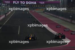 Sergio Perez (MEX) Red Bull Racing RB19 and Zhou Guanyu (CHN) Alfa Romeo F1 Team C43 battle for position. 08.10.2023. Formula 1 World Championship, Rd 18, Qatar Grand Prix, Doha, Qatar, Race Day.