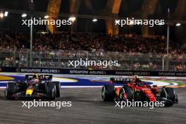 Max Verstappen (NLD) Red Bull Racing RB19 and Carlos Sainz Jr (ESP) Ferrari SF-23 battle for position. 17.09.2023. Formula 1 World Championship, Rd 16, Singapore Grand Prix, Marina Bay Street Circuit, Singapore, Race Day.