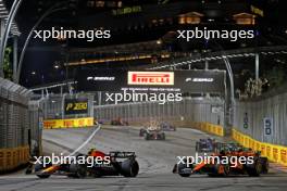 Sergio Perez (MEX) Red Bull Racing RB19 and Lando Norris (GBR) McLaren MCL60 battle for position. 17.09.2023. Formula 1 World Championship, Rd 16, Singapore Grand Prix, Marina Bay Street Circuit, Singapore, Race Day.